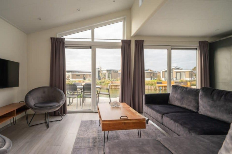 Sala moderna en Hackfort Waterfront 6, De Kraaijenbergse Plassen, Países Bajos, con vista al agua.