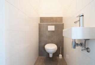 Bagno moderno con WC sospeso e piccolo lavabo all'Hackfort Waterfront 6, De Kraaijenbergse Plassen.