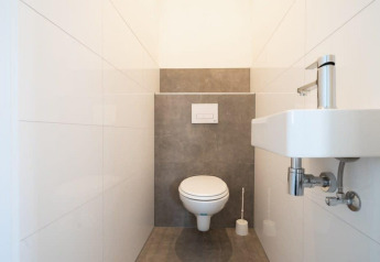 Bagno moderno con WC sospeso e piccolo lavabo all'Hackfort Waterfront 6, De Kraaijenbergse Plassen.