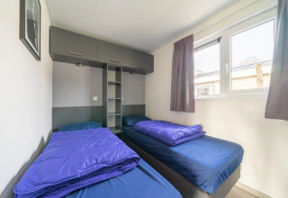 Due letti singoli con lenzuola blu nell'Hackfort Waterfront 6 a De Kraaijenbergse Plassen, Paesi Bassi.