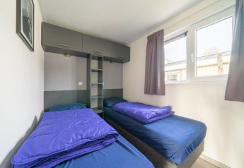 Due letti singoli con lenzuola blu nell'Hackfort Waterfront 6 a De Kraaijenbergse Plassen, Paesi Bassi.