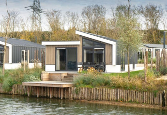 Moderno lodge Hackfort Waterfront 6 sul lungolago a De Kraaijenbergse Plassen, Paesi Bassi, immerso nella natura.