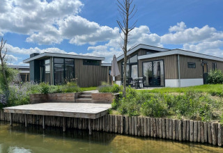 Lodge moderne Hackfort Waterfront 6 aux De Kraaijenbergse Plassen, Pays-Bas, avec terrasse sur l’eau.