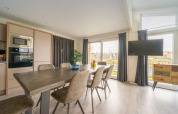 Moderne eetkamer in Hackfort Waterfront 8 lodge met zicht op De Kraaijenbergse Plassen in Nederland.