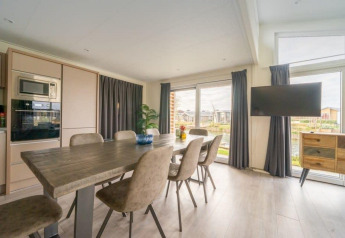 Moderne eetkamer in Hackfort Waterfront 8 lodge met zicht op De Kraaijenbergse Plassen in Nederland.