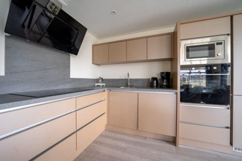 Cocina moderna en Hackfort Waterfront 8 lodge en De Kraaijenbergse Plassen, Países Bajos, con electrodomésticos integrados.