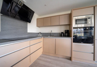 Cocina moderna en Hackfort Waterfront 8 lodge en De Kraaijenbergse Plassen, Países Bajos, con electrodomésticos integrados.