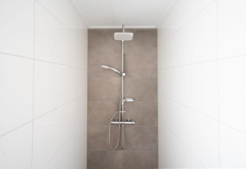 Moderne douche met wit en beige tegelwanden in Hackfort Waterfront 8, De Kraaijenbergse Plassen, Nederland.