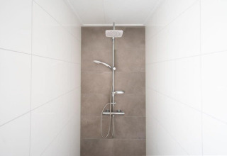 Ducha moderna con paredes de azulejos blancos y beige en Hackfort Waterfront 8, De Kraaijenbergse Plassen, Países Bajos.