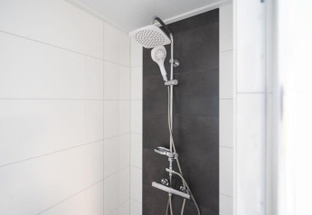 Moderne douche met dubbele douchekop en witte en donkere tegels, Pavilion 6, De Kraaijenbergse Plassen, Nederland.
