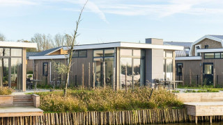 Lodge pavillon moderne au bord de l'eau avec grandes baies vitrées et terrasse, Pavilion Waterfront 6 entouré de nature.
