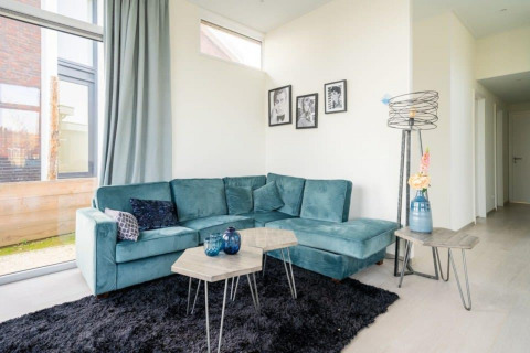 Sala moderna en Pavilion Waterfront 8, De Kraaijenbergse Plassen, Países Bajos, con sofá azul.