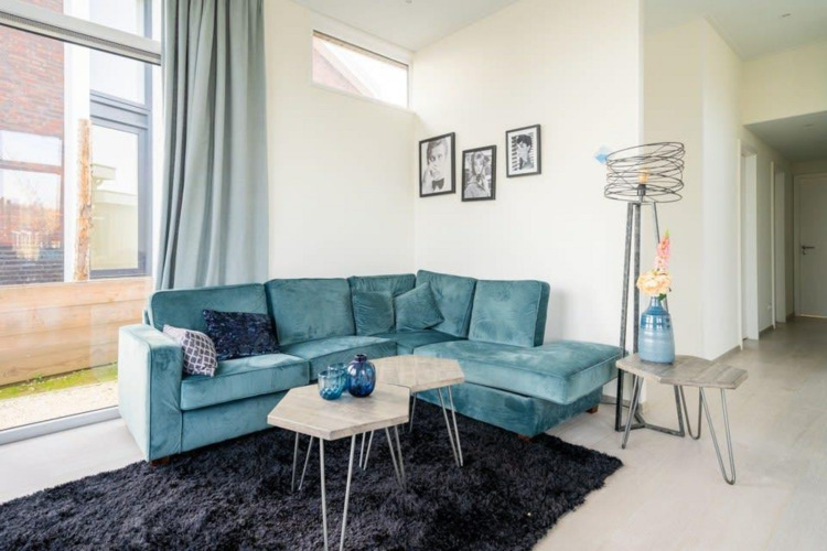 Sala moderna en Pavilion Waterfront 8, De Kraaijenbergse Plassen, Países Bajos, con sofá azul.