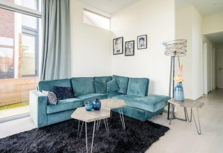 Sala moderna en Pavilion Waterfront 8, De Kraaijenbergse Plassen, Países Bajos, con sofá azul.