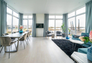 Luminoso y moderno salón comedor en Pavilion Waterfront 8, De Kraaijenbergse Plassen, Países Bajos, con amplios ventanales.