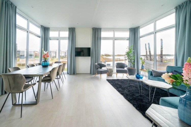 Luminoso y moderno salón comedor en Pavilion Waterfront 8, De Kraaijenbergse Plassen, Países Bajos, con amplios ventanales.