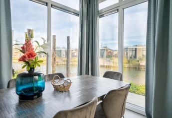Moderne eetkamer met grote ramen en uitzicht op het water bij Pavilion Waterfront 8, De Kraaijenbergse Plassen.