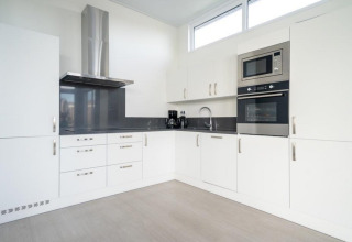 Moderne witte keuken in Pavilion Waterfront 8, De Kraaijenbergse Plassen, Nederland, met toestellen.