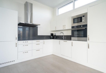 Moderne witte keuken in Pavilion Waterfront 8, De Kraaijenbergse Plassen, Nederland, met toestellen.