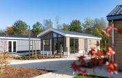 Lodge moderno Velthorst 4 en De Kraaijenbergse Plassen, Países Bajos, con vegetación y cielo azul.