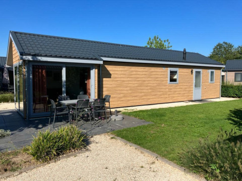 Velthorst 4 lodge aan De Kraaijenbergse Plassen in Nederland, met terras, tafel en stoelen buiten.