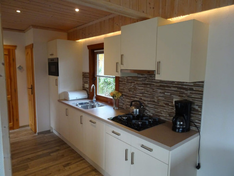 Moderne keuken in lodge Boekhorst, Limburg, Nederland, met witte kasten en houten elementen.