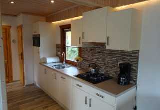 Moderne keuken in lodge Boekhorst, Limburg, Nederland, met witte kasten en houten elementen.