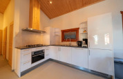 Moderne keuken in lodge Boekhorst in Limburg, Nederland, met witte kasten en houten plafond