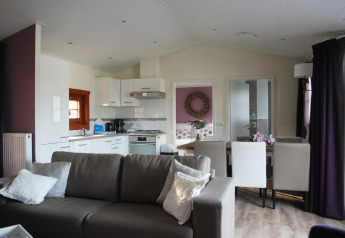 Soggiorno moderno con cucina a vista e zona pranzo nella lodge Boekhorst, Limburg, Paesi Bassi, arredamento accogliente.