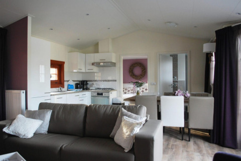 Sala moderna con cocina abierta y comedor en la cabaña Boekhorst, Limburg, Países Bajos, ambiente acogedor.