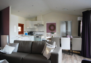 Sala moderna con cocina abierta y comedor en la cabaña Boekhorst, Limburg, Países Bajos, ambiente acogedor.