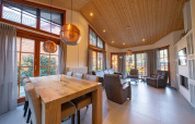Ampio soggiorno luminoso al Boekhorst lodge di Limburg, Paesi Bassi, con soffitto in legno e grandi finestre.