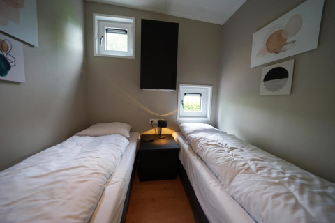 Camera di lodge moderna con due letti singoli e finestre a Just Nature, Limburg, Paesi Bassi.