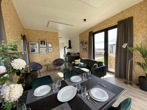 Interni moderni della lodge Just Nature Light a Limburg, Paesi Bassi, con sala da pranzo e ampie finestre.