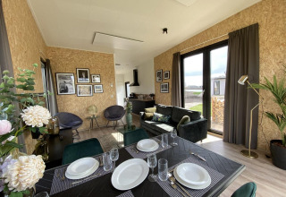 Interni moderni della lodge Just Nature Light a Limburg, Paesi Bassi, con sala da pranzo e ampie finestre.