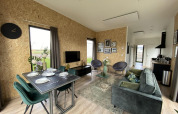 Moderne stue og spiseplads indrettet i Just Nature Light lodge i Limburg, Holland, med naturtema.