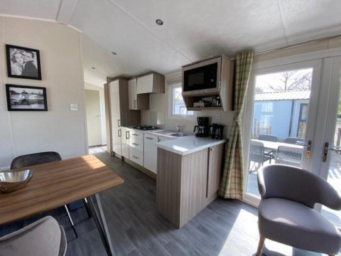 Cocina y comedor modernos en la cabaña Berkel 4 de Zuiderzee, Países Bajos, con vista a terraza exterior.