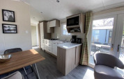 Modern kitchen and dining area in the Berkel 4 lodge at Zuiderzee, Netherlands, with terrace view outside.