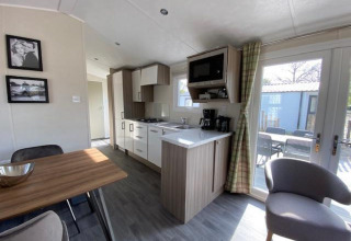 Cocina y comedor modernos en la cabaña Berkel 4 de Zuiderzee, Países Bajos, con vista a terraza exterior.