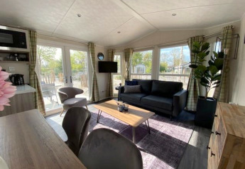 Zona giorno moderna nella lodge Berkel 4 a Zuiderzee, Paesi Bassi, con ampie vetrate e arredo elegante.