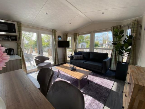 Sala de estar moderna en la cabaña Berkel 4 en Zuiderzee, Países Bajos, con ventanales y decoración elegante.