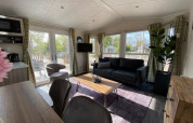 Moderne opholdsstue i Berkel 4-lodge ved Zuiderzee, Holland, med store vinduer og stilfuld indretning.