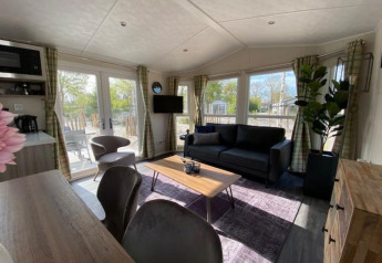 Moderne zithoek in Berkel 4 lodge aan het Zuiderzee, Nederland, met grote ramen en trendy decoratie.