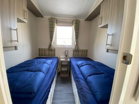 Schlafzimmer mit zwei Einzelbetten, blauer Bettwäsche und Schränken in Berkel 4, Zuiderzee, Niederlande.