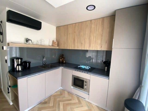 Petite cuisine moderne à Domus 4, Zuiderzee, Pays-Bas, avec armoires bois et gris et électroménagers intégrés.