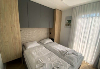 Chambre moderne à Domus 4, Zuiderzee, Pays-Bas, avec deux lits simples et décoration lumineuse.