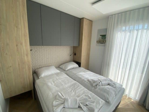 Camera moderna nella lodge Domus 4 a Zuiderzee, Paesi Bassi, con letti doppi e luce naturale.