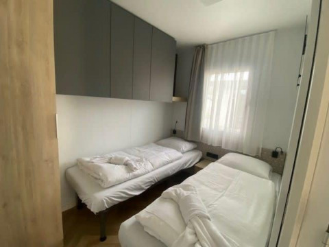 Twee eenpersoonsbedden in een lichte, kleine kamer van Domus 4 lodge bij Zuiderzee, Nederland.