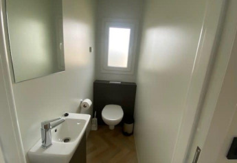 Moderne, compacte badkamer in Domus 4 te Zuiderzee, Nederland, met toilet, wastafel en raam.