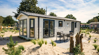 Lodge Berkel 6 moderne avec terrasse extérieure et mobilier, entourée de sable et de verdure en vacances.